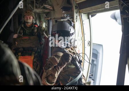 Sergent d'état-major de la Force aérienne des États-Unis Toiannah Campbell, chargée de charge du 36e Escadron de transport aérien C-130J, affiche un compte à rebours pour accompagner les maîtres-sauteurs de la Force terrestre d'autodéfense du Japon au-dessus de la zone d'entraînement de Narashino du JGSDF, au Japon, lors d'un saut bilatéral en avion, le 20 mai 2021. Cent quarante-trois parachutistes de la JASDF ont effectué des sauts aériens à partir du C-130J Super Hercules de la U.S. Air Force affecté au 36e Escadron de transport aérien afin d'améliorer les compétences tactiques nécessaires aux opérations aériennes. Banque D'Images