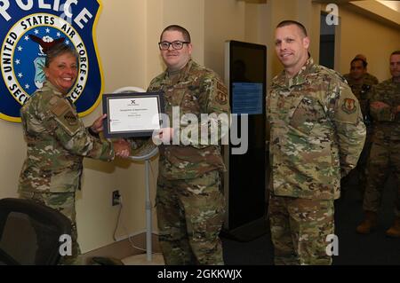 Le colonel Katrina Stephens, à gauche, commandant de l'installation, présente un certificat à Tech. Sgt. Kile Barrett, 66e Escadron de sécurité Surintendant de la sécurité pour l’installation, lors d’une présentation à la base aérienne de Hanscom, Mass., le 20 mai, alors que le Sgt. William Hebb regarde. Barrett a reçu un certificat pour avoir gagné ABG NCO de l'année plus tôt cette année. Banque D'Images