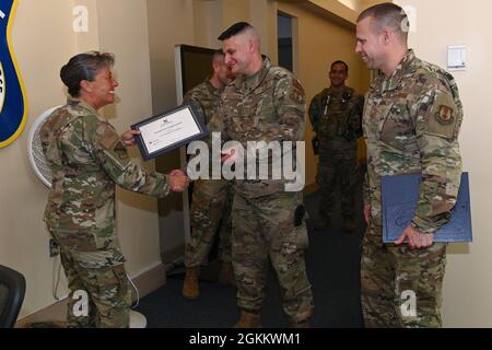 Le colonel Katrina Stephens, à gauche, commandant de l'installation, présente un certificat du Service d'échange de l'Armée de terre et de la Force aérienne à Airman, 1re classe Christopher Anderson, contrôleur d'entrée du 66e Escadron de sécurité, lors d'une présentation à la base de la Force aérienne Hanscom, Mass., mai 20, alors que le Sgt Sgt principal du Commandement Hanscom. William Hebb regarde. Banque D'Images