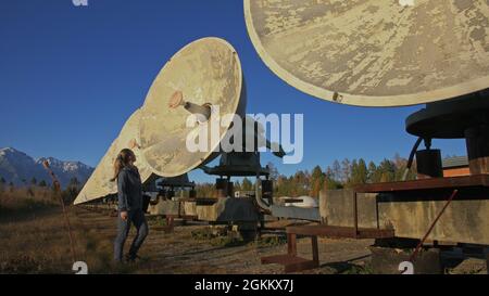 Une femme étudiante-opérateur de l'institut de physique terrestre solaire surveille les équipements de communication dans un ordinateur portable. Radiotélescope solaire à faisceau unique. DIM Banque D'Images