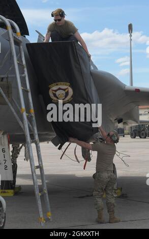 U.S. Air Force Tech. Sgt. Devin McKeever, 48e Escadron de maintenance des composants , technicien des systèmes de carburants (ci-dessous), Et Airman de 1re classe Thomas Sullivan (ci-dessus), chef d'équipage du 748e Escadron de maintenance d'aéronefs, remplace la couverture d'admission d'un aigle F-15C affecté au 493e Escadron de chasse lors de l'exercice Astral Knight 21 à la base aérienne de Larissa (Grèce), le 20 mai 2021. Durant l'Astral Knight 21, l'aile Liberty a renforcé sa capacité à déployer des forces capables et crédibles pour opérer à partir de sites stratégiques, ce qui est permis par de solides partenariats régionaux essentiels à une réponse unie rapide à l'adversaire Banque D'Images