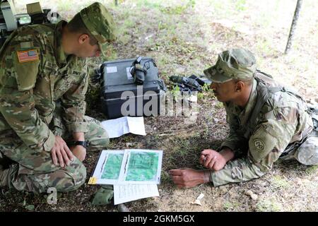 Sergent d'état-major de la Garde nationale de l'armée de New York. Sean Gilbert, de la troupe Bravo, 2e Escadron, 101e Régiment de cavalerie, vérifie les points de carte tracés par le Cpl. Kolby Williams, un scout de cavalerie affecté à la même troupe, pendant la partie de navigation terrestre de la compétition du meilleur guerrier de l'escadron à Ellicottville, New York, le 22 mai. L'événement a testé la forme physique et l'endurance, les connaissances et le roulement militaires, et les compétences de base du soldat pour déterminer qui représentera leur unité aux compétitions de brigade et d'état. Banque D'Images