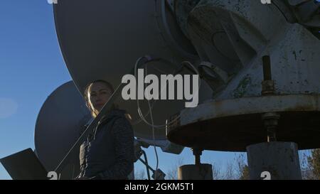 Une femme étudiante-opérateur de l'institut de physique terrestre solaire surveille les équipements de communication dans un ordinateur portable.Radiotélescope solaire à faisceau unique Banque D'Images