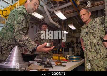 210524-N-SS370-1004 point POLARIS, Guam (24 mai 2021) le compagnon d'électricien de 2e classe Mark Weinreich présente les capacités de l'atelier de rembobinage à l'ADM arrière. Jeff Jablon, commandant, Force sous-marine, U.S. Pacific Fleet, lors d'une visite programmée à bord de l'appel d'offres sous-marin USS Frank Cable (AS 40), mai 24. Jablon a visité Cable et d'autres unités de la base navale de Guam, pour rencontrer des marins, discuter des opérations de l'unité avec la direction et évaluer les capacités des zones de première main. Banque D'Images