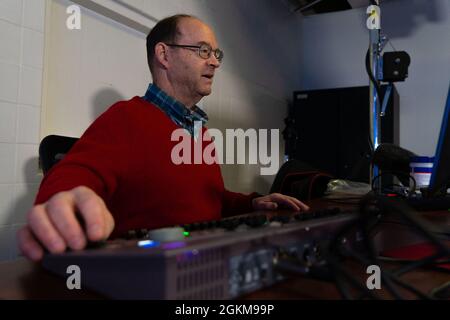 Denny Hostetter, spécialiste de l'engagement communautaire du bureau des affaires publiques de l'escadre de la base aérienne 673d, règle les lumières lors d'une séance vidéo à la base conjointe Elmendorf-Richardson, Alaska, le 24 mai 2021. L'engagement communautaire est responsable de l'exécution de programmes actifs de relations communautaires afin d'améliorer le moral, la confiance du public et le soutien. Banque D'Images