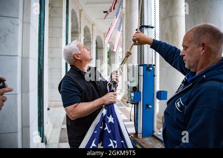 Charles 'Ray' Alexander, Jr. (Au centre), surintendant, cimetière national d'Arlington, et Dan Frye (à droite), électricien d'entretien des installations, cimetière national d'Arlington, aident à accrocher des drapeaux américains dans l'amphithéâtre Memorial du cimetière national d'Arlington, Arlington, Virginie, le 25 mai 2021. Banque D'Images