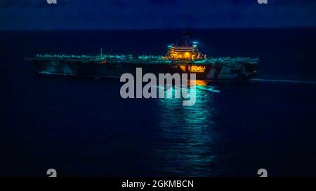 210525-N-JW440-4213 MER DES PHILIPPINES (25 mai 2021) le porte-avions de la classe Nimitz USS Ronald Reagan (CVN 76) transite la mer des Philippines de nuit. Reagan est le navire amiral du commandant de la Force opérationnelle 70/Carrier Strike Group 5, qui mène des opérations en cours à l'appui d'une Indo-Pacifique libre et ouverte. Banque D'Images