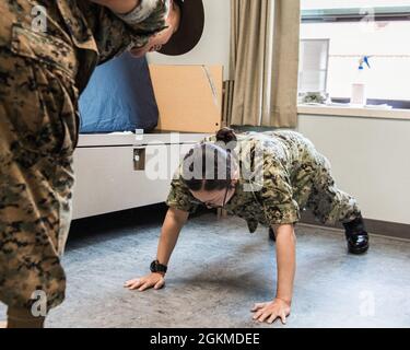 Un étudiant de classe 14-21 de l'École des candidats à l'emploi (OCS), au Commandement de la formation des officiers, Newport (OTCN), Rhode Island, effectue une formation de remise en forme physique pendant une inspection de la salle, du casier et du personnel, mai 26. L’inspection du RLP met à l’épreuve l’attention portée aux détails d’un officier candidat au sujet des connaissances militaires, des règlements d’inspection des uniformes et des chambres et de l’effort de conditionnement physique durant l’entraînement physique renforcé. OCS développe des civils et des marins de flotte en officiers nouvellement commissionnés moralement, mentalement et physiquement et les imprègne avec les idéaux les plus élevés d'honneur, de courage et d'engagement pour soi Banque D'Images