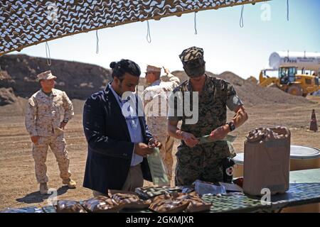 Anil Phull, militaire et employé des anciens combattants pour le bureau du sénateur Krysten Sinema, et le Capt lance Hill, 6e ingénieur soutien l'inspecteur-instructeur de Battaliong prennent le temps de savourer un repas prêt-à-manger avec les Marines à la route du comté de Pima à Tucson, Arizona, le 27 mai 2021. Le travail routier du comté de Pima est un projet novateur de programme de formation de préparation (IRT) qui consiste à reconstruire un tronçon de route de 2.3 milles qui sert de route quotidienne, d'aérodrome et d'itinéraire d'autobus. Le programme de TRI associe les besoins des communautés américaines aux besoins de formation de l'armée, ce qui les rend mutuellement bénéfiques. Banque D'Images