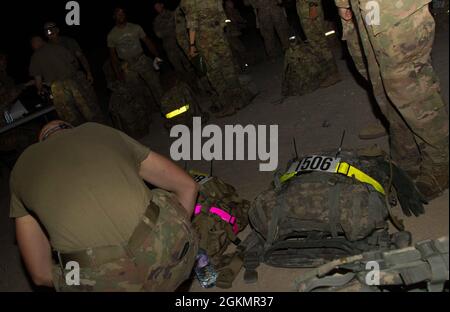 SPC de l'armée américaine. Peter Trey, le groupe de travail Helldrier, effectue des ajustements de dernière minute à son sac de ruck avant la partie de marche de 12 miles de la compétition du meilleur guerrier Spartan de TF pendant les premières heures du matin, le 29 mai 2021, au Camp Buehring, au Koweït. Les participants étaient tenus de terminer les 12 milles en trois heures, conformément aux normes de l'Armée de terre, pour gagner des points pour l'événement. Les soldats ont participé à la FTF Spartan BWC pour déterminer qui serait le « meilleur guerrier » pour passer à la compétition du Commandement central de l’Armée des États-Unis en juin 2021. Banque D'Images