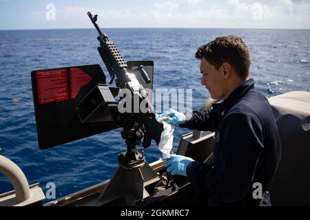 210529-N-RL695-1004 MER DES CARAÏBES - (29 mai 2021) -- le compagnon de Gunner de 3e classe Cody Harris effectue l'entretien d'une mitrailleuse M240B sur l'aile du pont à bord du navire de combat littoral Freedom-variant USS Sioux City (LCS 11), le 28 mai 2021. Sioux City est déployée dans la zone d’opérations de la 4e flotte des États-Unis pour appuyer la mission de la Force opérationnelle interagences conjointe Sud, qui comprend des missions de lutte contre le trafic illicite de drogues dans les Caraïbes et le Pacifique oriental. Banque D'Images
