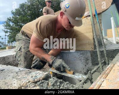 KWAJALEIN, Îles Marshall (29 mai 2021) le constructeur de 3e classe Ryan Coyne, affecté au bataillon de construction mobile navale (NMCB) 4, crée une finition lisse du béton dans le cadre du projet de théâtre Richardson. Ce projet s'améliore sur le théâtre, construit pour la première fois par les Seabees dans les années 1940. Le NMCB-4 est déployé dans toute la région Indo-Pacifique et aux États-Unis, prêt à soutenir les opérations de combat majeures, la sécurité du théâtre, l'aide humanitaire et les opérations de secours en cas de catastrophe. Banque D'Images