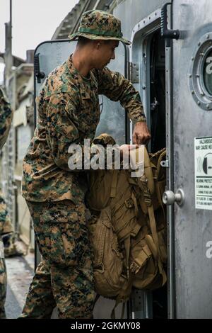 Caporal du corps des Marines des États-Unis Jason Montalvo, ingénieur de combat avec Alpha Company, 9e Bataillon de soutien technique, 3d Marine Logistics Group (MLG), charge son équipement dans un coussin d'air d'embarcation d'atterrissage (LCAC) sur la base navale de White Beach, Okinawa, Japon, le 1er juin 2021. Marines de mlg 3d et marins de l’unité Naval Beach 7 intégrés pour charger et transporter du personnel et de l’équipement à l’appui de la tour de surveillance de l’exercice Poseidon. La NBU-7 est une unité opérationnelle déployée à l'avant qui contribue directement aux capacités de base de la Maritime Sea Power des États-Unis en facilitant le mouvement des troupes, de l'équipement, des véhicules et Banque D'Images