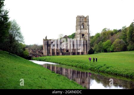 Les gens qui marchent à côté de Gray marchent sur la rivière Skell à l'abbaye de Fountains près de Ripon dans le North Yorkshire, Angleterre, Royaume-Uni. Banque D'Images