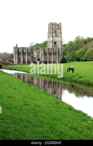 Les gens qui marchent à côté de Gray marchent sur la rivière Skell à l'abbaye de Fountains près de Ripon dans le North Yorkshire, Angleterre, Royaume-Uni. Banque D'Images