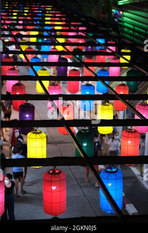 Les gens erraient dans le marché de rue nocturne sous la verrière de lanternes colorées Banque D'Images