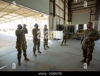 Sgt. Commandement Le Maj Michael Perry, conseiller principal du 1er Commandement du soutien du théâtre, présente une pièce de remise en cause à FPC. Jasmine Mullins, commis postal, 847e Compagnie de ressources humaines, au terminal militaire mixte du poste à Camp Arifjan (Koweït), le 2 juin 2021. Au cours de sa visite, les soldats ont partagé la façon dont ils gèrent les opérations de courrier et traitent le courrier pour toutes les unités et les membres de service de la région. Banque D'Images