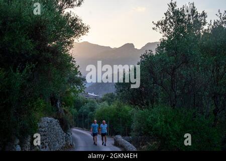 Deux hommes marchent sur une route de campagne dans la Serra de Tramuntana à l'extérieur de Selva, Majorque, Espagne Banque D'Images