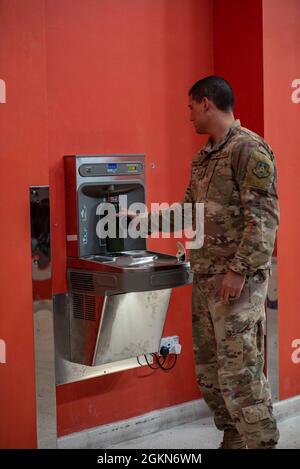 Le 2e lieutenant Richard Rosario-Santiago, 379e commandant de service de vol de l'escadron du génie civil expéditionnaire, remplit sa bouteille d'eau à l'aide du nouveau système de filtration de l'eau au gymnase du complexe Blachford-Preston le 3 juin 2021, à la base aérienne Al Udeid, au Qatar. Le 379e ingénieur bioenvironnemental de la base ECES a procédé à un examen complet de l'infrastructure d'eau potable de l'AUAB, ce qui a permis au 379e Groupe médical expéditionnaire de considérer le système de filtration comme une source fiable d'eau potable. Banque D'Images