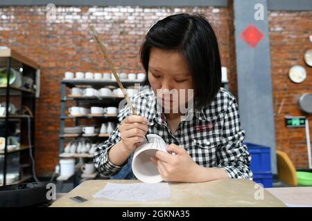 Xuanhua, Xuanhua, Chine. 15 septembre 2021. Le 15 septembre 2021, les visiteurs découvrent la peinture sous-glaçante au Musée national de céramique de Jade, dans le district de Xuanhua, dans la ville de Zhangjiakou, province de Hebei. Ces dernières années, le district de Xuanhua, ville de Zhangjiakou, province de Hebei, a exploré à fond l'histoire industrielle et la culture. Dans la mise en œuvre de la relocalisation et de la transformation de l'ancienne zone industrielle, Xuanhua Guoyu Ceramics Co., Ltd. A déplacé les anciens ateliers et lignes de production qui ont une histoire de plus de 60 ans dans un musée de céramique. À travers les images et les objets physiques, le h Banque D'Images