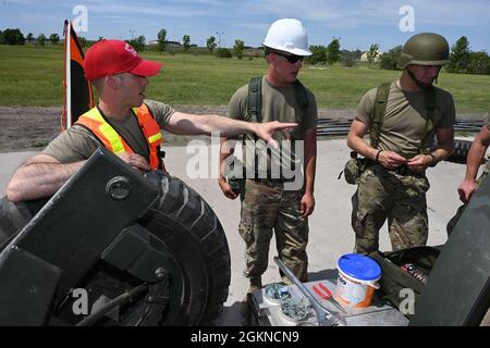 De gauche à droite, les membres de la U.S. Air Force du 119e Escadron de génie civil Tech. Sgt. Luke Knutson, un instructeur de site d'entraînement régional, fournit des conseils à Joseph Ellison, classe 1 d'Airman, et à Jack Sullivan, membre principal de l'Airman, lors d'un exercice de préparation à la base de la Garde nationale aérienne du Dakota du Nord, Fargo, N.D., le 4 juin 2021. L'exercice de préparation est conçu pour préparer tous les secteurs du personnel de l'unité au déploiement dans des environnements contestés, dégradés et limités sur le plan opérationnel (CDO) et à l'augmentation du niveau de menace. Banque D'Images