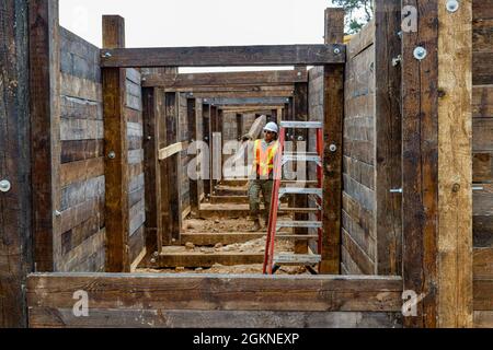 SPC. Matthew Lynch, un ingénieur de construction horizontal avec troisième peloton, troupe d'Argonaut, Escadron de génie régimentaire, 2e Régiment de cavalerie, porte un conseil lors de la construction d'une tranchée de 100 mètres sur la zone d'entraînement de Hohenfels, Hohenfels, Allemagne. La tranchée sera utilisée pour un certain nombre d'événements de formation tout au long de l'année, à commencer par le concours européen du meilleur Sniper du 5-14 août sur HTA. Banque D'Images