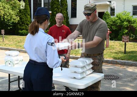 Sgt. Maître Anthony Poulin, à droite, premier sergent du 66e Escadron de contrôleur, remet une plaque de barbecue à la 1re classe d’Airman Kelly Funk, technicien des opérations financières du 66e Escadron de contrôleur, lors d’un premier collecteur de fonds du premier sergent à la base de la Force aérienne Hanscom, au Massachusetts, en juin 7, alors que le Sgt principal. John Tremblay, Centre de gestion du cycle de vie de la Force aérienne, Détachement 7, premier sergent, regarde. Le premier Sergent-conseil de Warhawk a tenu l'événement pour recueillir de l'argent pour l'opération Warm Heart. Banque D'Images