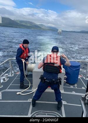 Les membres de l'équipage de la station de garde côtière Ketchikan, l'officier Petty de 3e classe Corben Hill (à gauche) et l'officier Petty de 3e classe Caleb Hoskins travaillent une ligne de remorquage pour un yacht près de Ketchikan, après qu'un autre équipage Ketchikan ait passé le capitaine du yacht le 9 juin 2021. L'équipage du bateau précédent a travaillé avec des ambulanciers paramédicaux du service des pompiers volontaires de South Tongass pour transporter le capitaine de yacht de 86 ans à l'EMS sur terre, après avoir éprouvé des symptômes d'accident vasculaire cérébral. Banque D'Images