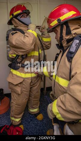 Dommage Controlman Fireman Francisco Ruiz, à droite, de San Diego, affecté au département d'ingénierie de Ford, Buddy cheques Seaman Maricruz Deloa, de Victorville, Californie, affecté au département d'approvisionnement de l'USS Gerald R. Ford (CVN 78), tout en donnant des ensembles de lutte contre l'incendie lors d'un exercice de quartier général, le 9 juin 2021. Ford est en cours dans l'océan Atlantique en menant des essais de choc en pleine mer (FSST). La Marine américaine effectue des essais de choc sur de nouveaux modèles de navires à l'aide d'explosifs vivants pour confirmer que nos navires de guerre peuvent continuer à répondre aux exigences de mission exigeantes dans des conditions difficiles qu'ils pourraient rencontrer Banque D'Images