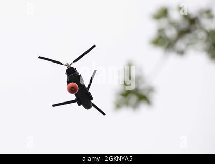 Un hélicoptère Chinook CH-47 du 1er Bataillon, 207e Régiment d'aviation, muni d'un système de seaux à eau Bambi, survole pendant la certification Red Card de l'unité sur la base interarmées Elmendorf-Richardson, le 9 juin 2021. La certification Red Card, également connue sous le nom de « incident qualification Card », est une certification interagence acceptée selon laquelle une personne est qualifiée pour accomplir la mission requise lorsqu'elle arrive sur un incident. Pour les pilotes du 1-207e AVN, cette certification signifie une maîtrise des chutes de seaux d'eau pour aider aux situations d'urgence en cas d'incendie de forêt dans l'État. Banque D'Images