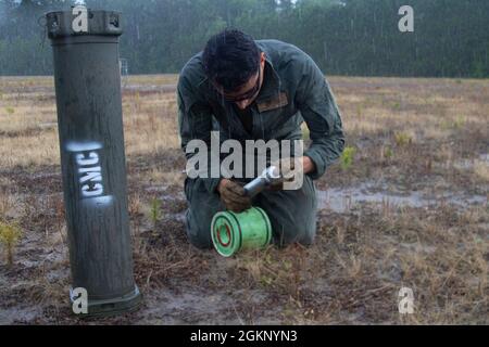 Sergent du corps des Marines des États-Unis Alexander Maxwell, Odomyter Ordnance Disposal, Headquarters et Headquarters Squadron, prépare une bombe à pipe lors d'une aire d'entraînement conjointe avec l'équipe d'intervention des forces spéciales du comté de Carteret à la station aérienne du corps des Marines Cherry point, en Caroline du Nord, le 9 juin 2021. Les bombes à pipe ont été placées devant des cibles en forme d'homme pour simuler les effets de la bombe sur le corps humain. Banque D'Images