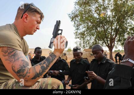 Sergent de l'armée américaine Matthew Bryant, soldat d'infanterie de la 2e Brigade d'assistance des forces de sécurité, montre comment démonter un pistolet aux soldats du bataillon djiboutien intervention rapide (BIR) à Djibouti, le 9 juin 2021. La 2e Brigade d'assistance des forces de sécurité a fourni une formation aux soldats du BIR au cours des derniers mois. Banque D'Images