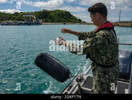 WHITE BEACH, Japon (juin 10, 2021) le compagnon de Boatswain de 2e classe Damian Bowlin, affecté au commandant, activités de la flotte Okinawa, jette une aile sur le côté d’un bateau utilitaire en préparation à l’amarrage du quai à l’installation navale de White Beach, Okinawa (Japon) le 10 juin 2021. Banque D'Images