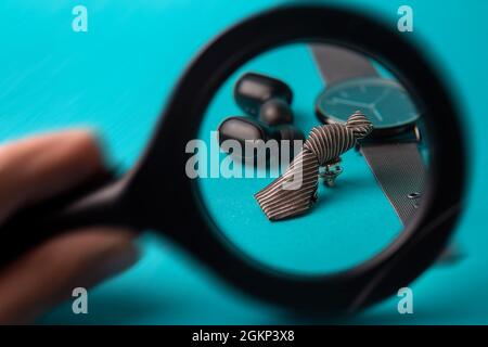 casque sans fil et montre avec cravate sur fond bleu. Banque D'Images