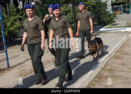 DNIPRO, UKRAINE - 14 SEPTEMBRE 2021 - des soldats de la Garde nationale d'Ukraine dirigent un chien de service nommé Jack par la laisse lors de l'événement caritatif ukrainien Dumpling Holiday organisé pour les élèves de l'orphelinat Barvinok par l'équipe de la Real Dreams Charitable Foundation, Dnipro, Ukraine orientale Banque D'Images