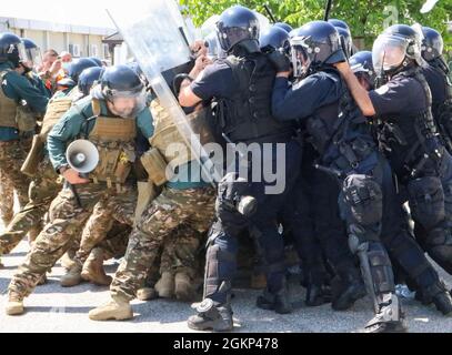 Des soldats des forces armées slovènes s'opposent aux officiers de police du Kosovo lors de l'opération Swift Rescue à l'aérodrome de Gjakova/Gjakovë au Kosovo le 10 juin 2021. L'opération était l'exercice multinational de formation sur le terrain le plus complexe qui ait été mené récemment dans l'histoire de la Force au Kosovo. Les troupes slovènes ont joué le rôle de manifestants civils pendant l'exercice, tandis que les officiers régionaux du PK ont répondu aux premiers rapports d'une perturbation publique. Banque D'Images