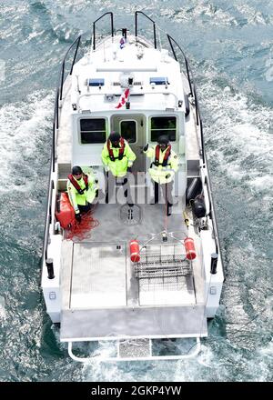 Les membres d'équipage de bateau de la police provinciale de l'Ontario tendent la ligne de piste pendant l'entraînement avec l'équipage de la station aérienne traverse City, Michigan, le 10 juin 2021. L'équipage a également mené une formation avec la Gendarmerie royale du Canada et la Station de la Garde côtière Sault Ste Marie. Banque D'Images