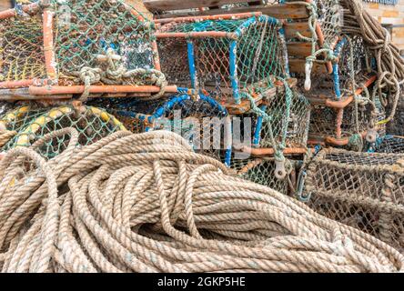 Cordages nautiques et vieilles marmites de homard sur le quai du port de pêche. Banque D'Images