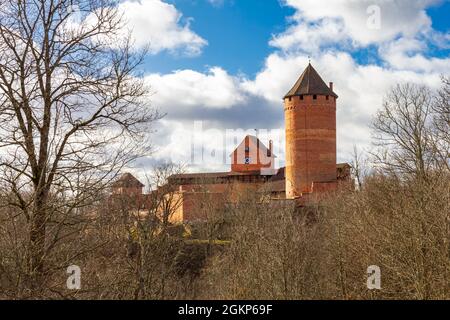 Vue sur le château de Turaida et la rivière Gauja au coucher du soleil à Sigulda, Lettonie. Automne doré avec forêt d'orange et rivière au bord du château, lieu touristique Banque D'Images