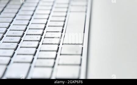Détail d'un clavier d'ordinateur blanc moderne sale et poussiéreux sur une table blanche. Périphérique matériel informatique. Technologie et Internet Banque D'Images