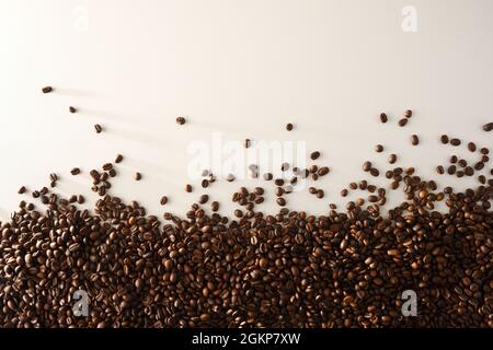 Pile de grains de café naturellement séchés d'un côté sur la table blanche. Vue de dessus. Composition horizontale. Banque D'Images