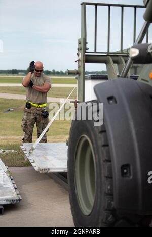 Le principal Airman Ricardo Aguilera-Salas, un porteur aérien de la Garde nationale aérienne de Porto Rico, qui était en voie d'augmenter le 123e groupe d'intervention en cas de conflit de la Garde nationale aérienne du Kentucky, guide le fret pendant l'opération Lone Oak à Volk Field, Wisconsin, le 11 juin 2021. Des porteurs aériens ont déplacé la cargaison 24 heures sur 24 pendant l'exercice. Banque D'Images