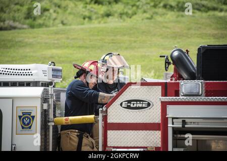 Les pompiers de la 193e Escadron de génie civil des opérations spéciales, de la Garde nationale de l'air de Pennsylvanie, utilisent une pompe sur leur véhicule le 12 juin 2021 à l'école de pompiers du comté de York, à York, en Pennsylvanie. Les pompiers de la Pennsylvania Air et de la Garde de l'Armée ont travaillé ensemble pour mener divers scénarios d'entraînement en direct à l'incendie. Banque D'Images