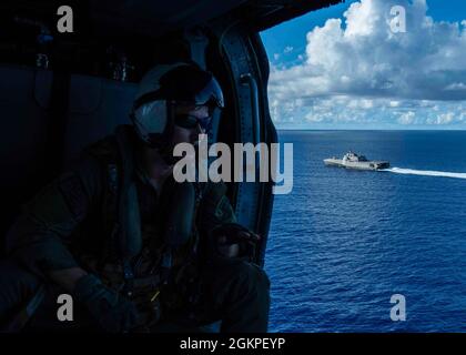 OCÉAN PACIFIQUE (13 juin 2021) Aircrewman naval (hélicoptère) de 2e classe Trenton B. Coble, d'Edgewood, Texas, affecté à l'Escadron de combat en mer (HSC) 21, guide un hélicoptère MH-60S Sea Hawk lors d'un exercice de reconstitution verticale à bord du navire de combat littoral Independence-variant USS Tulsa (LCS 16). Tulsa, qui fait partie de l'escadron Destroyer Seven, est en cours de déploiement rotatif dans la zone d'opérations de la 7e flotte américaine afin d'améliorer l'interopérabilité avec ses partenaires et de servir de force de réaction prête à l'emploi pour soutenir une région Indo-Pacifique libre et ouverte. Banque D'Images