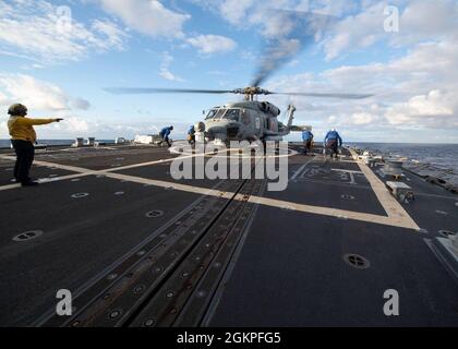 210613-N-CZ893-1220PACIFIC OCEAN (le 13 juin 2021) des marins sécurisent un chasseur de mer MH-60R, affecté à l'escadron de frappe maritime d'hélicoptère (HSM) 37, au pont de vol du destroyer de la classe Arleigh Burke USS Howard (DDG 83) le 13 juin 2021. Howard mène actuellement des opérations maritimes de routine dans la zone d'exploitation de l'île Hawaiian. Banque D'Images