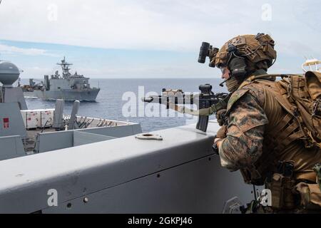 210614-N-XB010-1027 MER DE CHINE ORIENTALE (14 juin 2021) Une Marine attachée à la 31e unité expéditionnaire maritime (MEU) communique le statut du pont de l'USS New Orleans (LPD 18) par radio lors d'une évolution de l'entraînement de la Force de RAID maritime avec l'USS Germantown (LSD 42), arrière. La Nouvelle-Orléans, qui fait partie du America Amphiobie Ready Group, ainsi que de la 31e Marine Expeditionary Unit, opère dans la zone de responsabilité de la 7e flotte des États-Unis pour améliorer l'interopérabilité avec les alliés et les partenaires et servir de force de réponse prête à l'emploi pour défendre la paix et la stabilité dans la région Indo-Pacifique. Banque D'Images