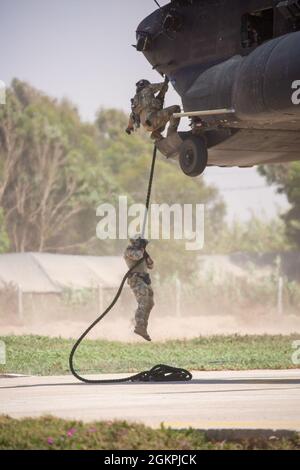 Soldats des forces spéciales de l'armée américaine affectés au 19e Groupe des forces spéciales (Airborne), Garde nationale de l'armée de l'Utah, parachutistes de l'armée royale marocaine, Et les commandants de la Marine royale marocaine conduisent un entraînement rapide de corde à partir d'un Chinook MH-47 du 160e Régiment d'aviation d'opérations spéciales lors de l'exercice African Lion 2021 à Tifnit Maroc, Afrique, le 14 juin 2021. African Lion 2021 est l'exercice annuel le plus important, conjoint et le plus important du Commandement de l'Afrique des États-Unis, organisé par le Maroc, la Tunisie et le Sénégal, le 7-18 juin. Plus de 7,000 participants de neuf nations et de l'OTAN s'entraînent ensemble en mettant l'accent sur l'amélioration de la réadmission Banque D'Images