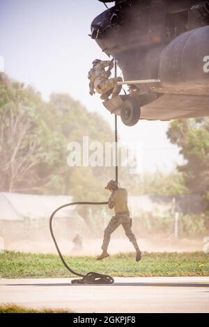 Soldats des forces spéciales de l'armée américaine affectés au 19e Groupe des forces spéciales (Airborne), Garde nationale de l'armée de l'Utah, parachutistes de l'armée royale marocaine, Et les commandants de la Marine royale marocaine conduisent un entraînement rapide de corde à partir d'un Chinook MH-47 du 160e Régiment d'aviation d'opérations spéciales lors de l'exercice African Lion 2021 à Tifnit Maroc, Afrique, le 14 juin 2021. African Lion 2021 est l'exercice annuel le plus important, conjoint et le plus important du Commandement de l'Afrique des États-Unis, organisé par le Maroc, la Tunisie et le Sénégal, le 7-18 juin. Plus de 7,000 participants de neuf nations et de l'OTAN s'entraînent ensemble en mettant l'accent sur l'amélioration de la réadmission Banque D'Images