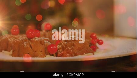 Image d'une assiette avec pudding de noël et lumières brillantes Banque D'Images