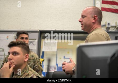 Sergent-chef de la Force aérienne des États-Unis Perry Otillio, directeur de la section du Centre des opérations de maintenance du 18e Groupe de maintenance, discute des plans d'exploitation à la base aérienne de Kadena, au Japon, le 14 juin 2021. Le MOC donne aux commandants un aperçu de l’état de l’aéronef de Kadena, y compris l’état de la capacité de la mission et le type d’aéronef. Banque D'Images